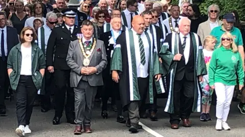 Men and women walk in a large group in the Beating the Bounds ceremony