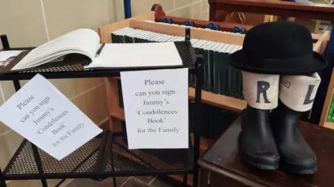 Paul Burnell/BBC Stage welies and bowler hat by book of condolence