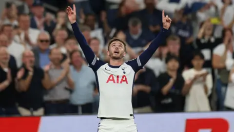 ANDY RAIN/EPA-EFE/REX/Shutterstock James Maddison, on a football pitch, celebrates with his hands in the air and his head turned up to the sky.