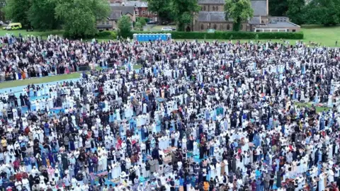 Hundreds of Muslims pray in Platt Fields Park, Manchester, for a previous year's Eid.