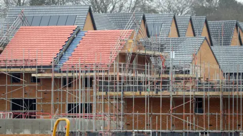 PA Housing under construction - with scaffolding all over it - brown houses with peaked roofs