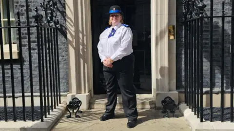 Chrissie Moyes A woman in a PCSO uniform stands outside of number 10 Downing Street.