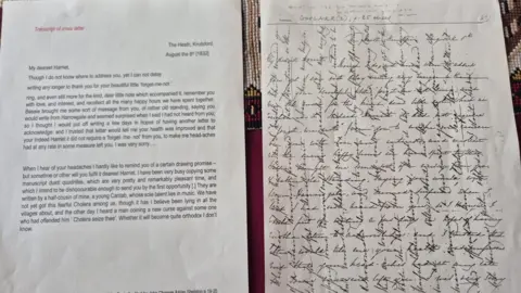 A paper on the left shows a typed version of a letter from Gaskell, while a paper ont he left shows a image of the orignal letter written in crosshatch where horizontal lines intersect with vertical lines