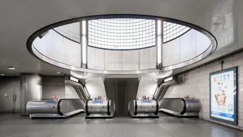 The station has a circular glass window above the escalators. 