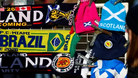 A selection of colourful football scarves celebrating Scotland's appearance at the men's World Cup this summer on sale at a stand before a match.