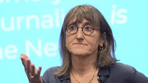 Baroness Kidron wears a grey t-shirt and tortoiseshell glasses