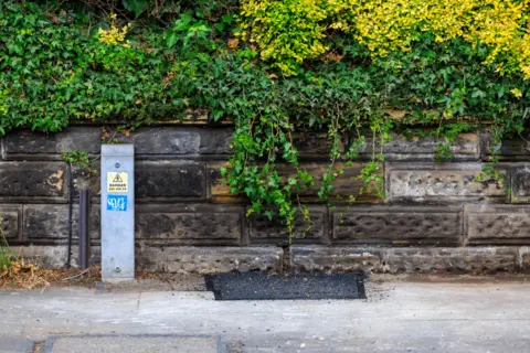 Greater Manchester Police The empty space where the speed camera was on Edge Lane, which has been filled in with bitumen