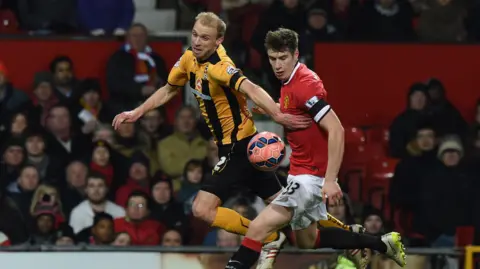Getty Images Luke Chadwick, fighting for the ball with a Manchester United player - this time, wearing the black and yellow colours of Cambridge United. 