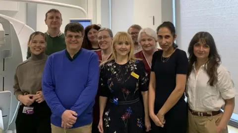 University Hospitals Sussex NHS Foundation Trust A group of people standing in three lines posing for a photo
