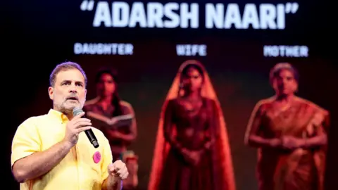 Congress party Rahul Gandhi, wearing a bright yellow shirt and holding a mic, addresses a gathering at an students' event in Pune. 
