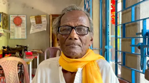 Kanailal Hait, an elderly Indian man who survived the 1943 Bengal famine, wearing a white kurta and yellow scarf