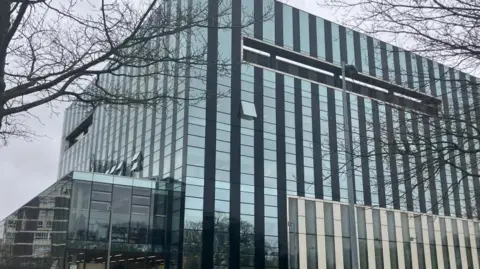 A large glass building with hundreds of square glass windows.