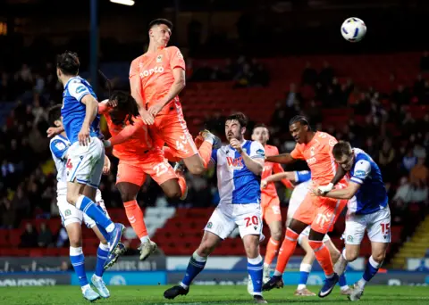 PA Media Coventry City footballer Bobby Thomas pictured surrounded by Blackburn Rovers players and orange-shirted teammates after heading the ball towards the Blackburn net.