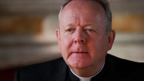 Archbishop Eamon Martin, with short grey hair, dressed in black and pictured from the shoulders up.