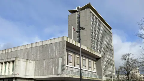 Council House in Plymouth. The building is grey and has lots of windows. 