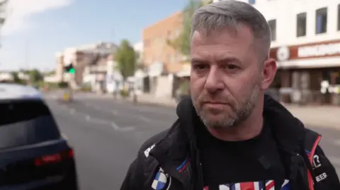 Man with beard in black biker gear