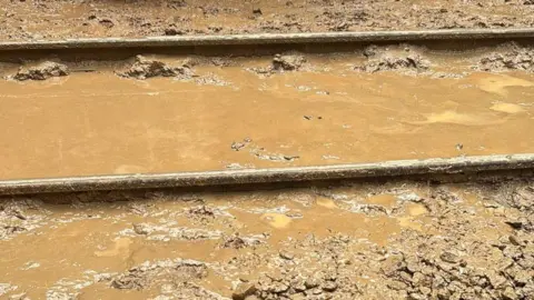 Network Rail Wessex A train track swamped in brown thick mud