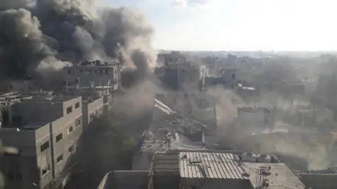 Reuters Smoke rises following Israeli strikes in Bureij refugee camp, in the central Gaza Strip, on 19 October 2025
