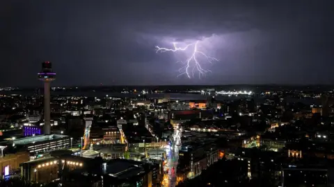 A lightning bolt forks over the Liverpool skyline at night 