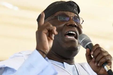 Getty Images Former Nigerian vice president Atiku Abubakar wearing a traditional gown and holding a microphone
