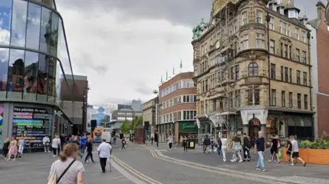 Dozens of people walking up and down Blackett Street. Eldon Square shopping centre can partly be seen on the lefthand side, with Waterstones and Fenwick on the right.
