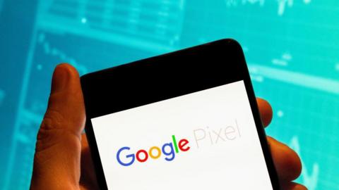 In this photo illustration, the American android consumer electronic devices developed by Google, Google Pixel logo seen displayed on a smartphone with an economic stock exchange index graph in the background. (Photo Illustration by Budrul Chukrut/SOPA Images/LightRocket via Getty Images)