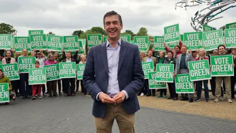 Paul Moseley/BBC Adrian Ramsay in front of party supporters