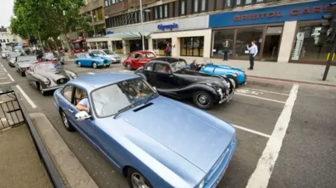 Bristol 24/7 An old photograph of lines of vintage cars on a Bristol street in front of the former Bristol Cars salesroom