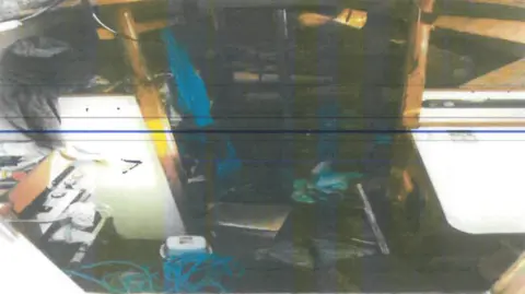 Guardia Civil A messy scene inside Nunan's boat. The image is dark but items can be seen strewn all over the interior, including lots of blue rope.