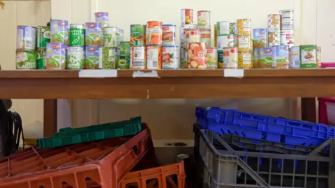 Laurence Cawley /BBC Cans of food at the food bank 