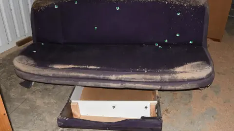 Police handout A dirty and battered brown sofa bed with a drawer underneath recovered by police.