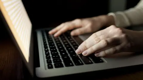 A stock photo of woman's hands using a laptop. 