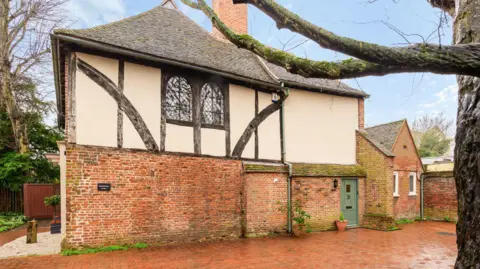 Finn's A large brick ad plaster house in Tudor style. It appears to be very old.