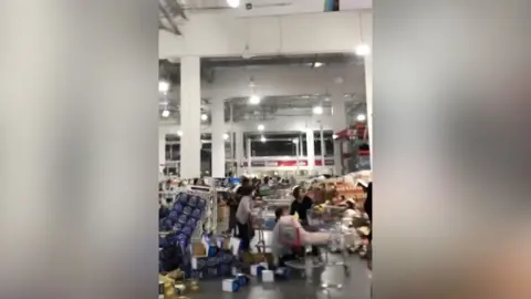 People ducking inside a chaotic supermarket