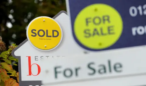 PA Media Three signs with the words 'for sale' and 'sold' on them.