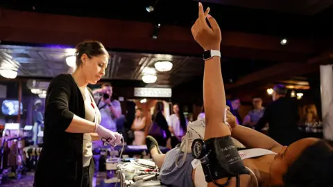 Getty Images Woman holds hand in the air following blood donation