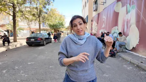 Carine Torbey in grey jumper and blue scarf