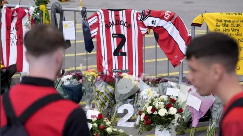 PA Images Tributes to footballer George Baldock were left outside Sheffield United's ground Bramall Lane