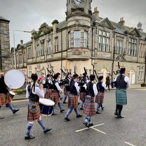 Lochgelly High School Music Department Piping band marching down street