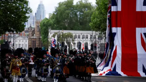 BENJAMIN CREMEL/Pool via REUTERS Soldiers march past Cenotaph in London draped in Union flags