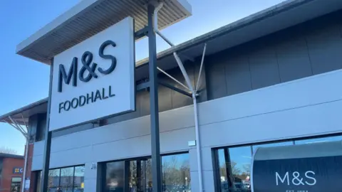 The outside of a retail unit with a large sign that reads: "M&S Foodhall." 