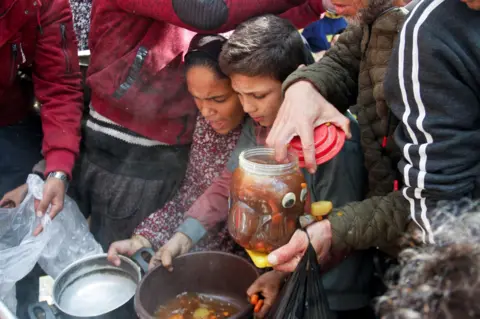 Reuters People queuing for food in Gaza