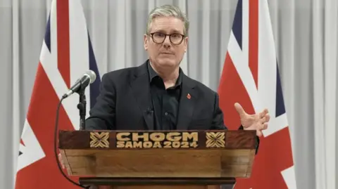 Reuters Prime Minister Sir Keir Starmer speaking at a podium which reads 'CHOGM Samoa 2024' in front of two Union flags