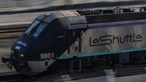 A silver train with "LeShuttle" written on the side.