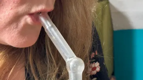 Woman using a vaporiser for medicinal cannabis