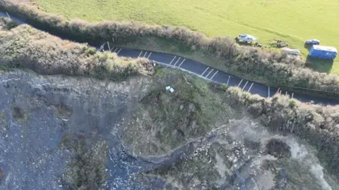 Aerial image of coastal road falling into the sea. 