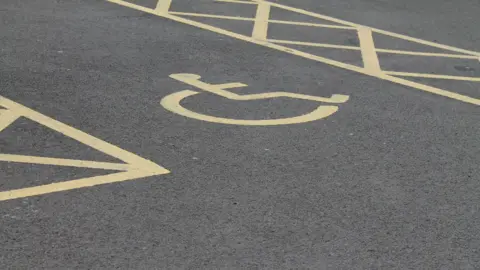 BBC A disabled parking bay with the wheelchair logo.