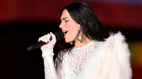 Getty Images Dua Lipa sings during a concert at Wembley Stadium