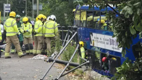 Bus in the water surrounded by fire services
