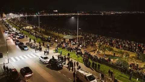 Douglas Council/Matt Mosur Large crowds filling Douglas Promenade with the road, cars and street lights.